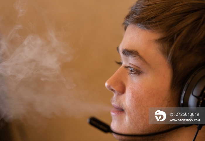 teenager vapes while video gaming