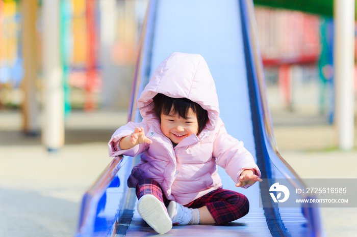 公園の滑り台で遊ぶかわいい子供