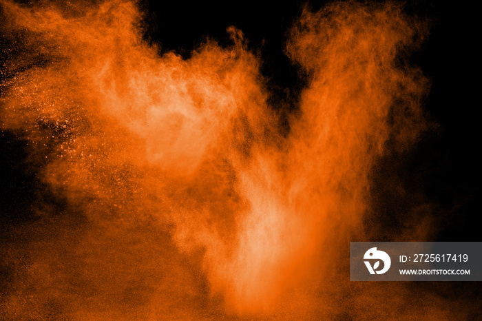 橙色粉末在黑色背景下的抽象爆炸。橙色粉末飞溅的冻结运动。
