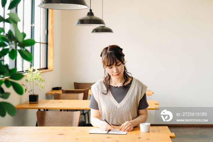 カフェで勉強する女性（ノート）