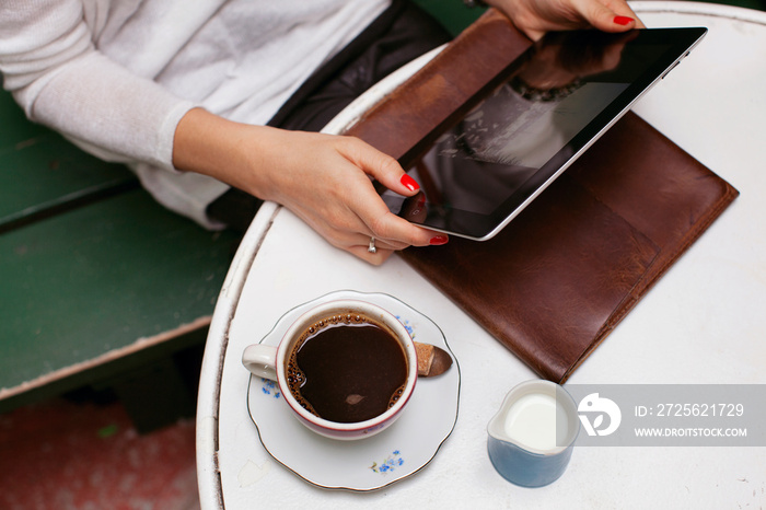 Midsection of woman using digital tablet in cafe