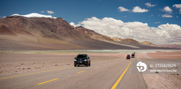 Road in the Andes region Chile next to high volcanos and blue lagoon