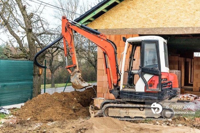 建筑工地上的小型挖掘机。建造家庭住宅。建造供水