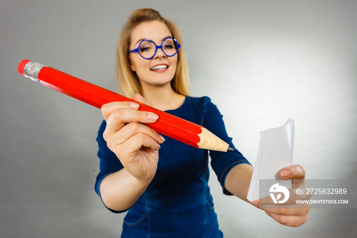 woman holds big pencil note paper in hand