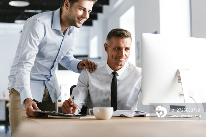 Image of Smiling Two colleagues working together by the computer