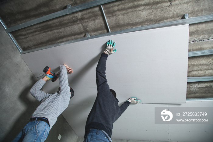 工人将面板安装到天花板框架中。