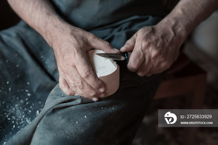 Hands carving cup from wood, working with chisel close up. Wooden workshop. Process of making wooden