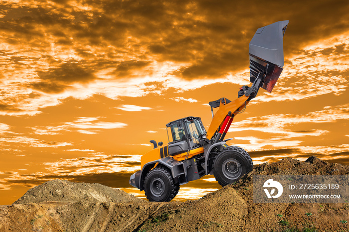 excavator working on construction site in front of dramatic sky