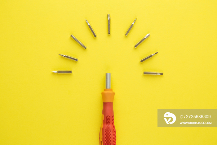 Top view of small screwdrivers set tool kit abstract isolated on yellow.