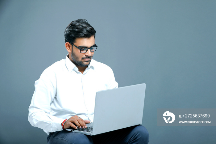 young indian employee with laptop