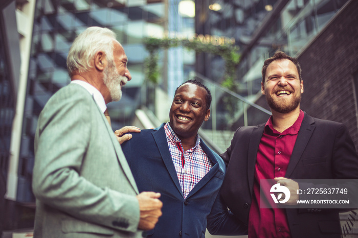 Three business men talking on street.