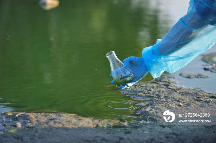 在采集受污染水样本的过程中，一名研究人员的环保手被特写