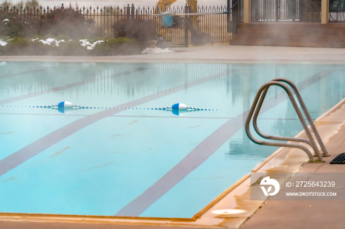 Blue and white buoy and rope lane marker floating on an outdoor swimming pool