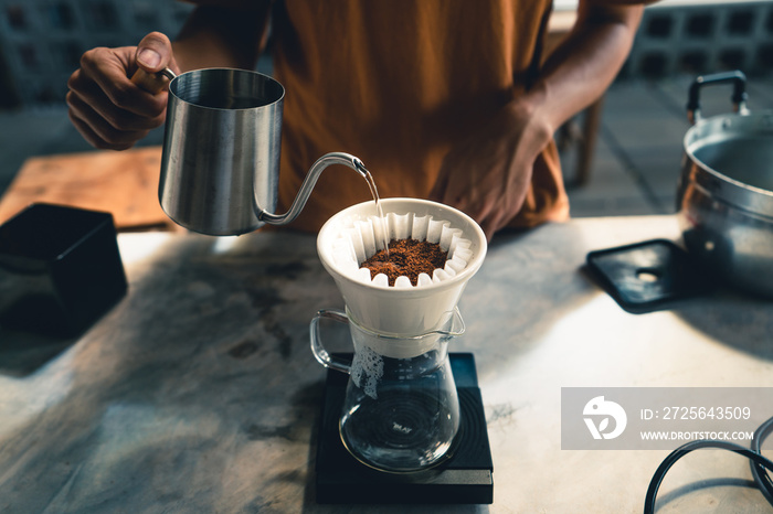 Drip coffee, barista pouring water on coffee ground with filter