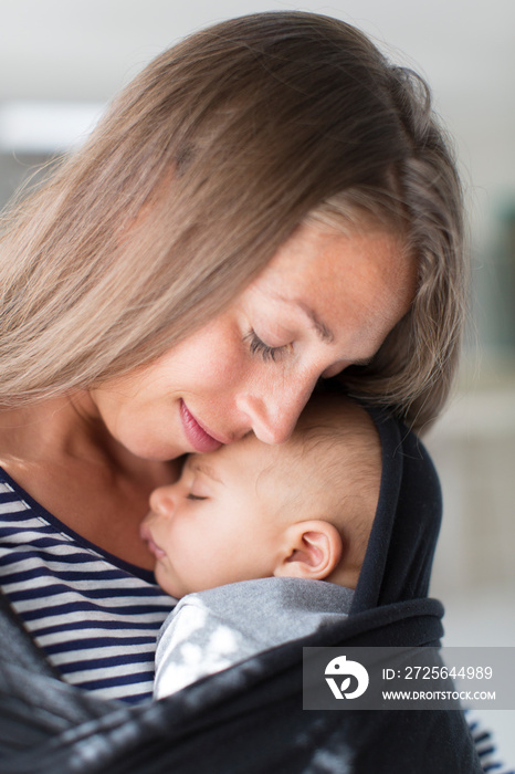 Affectionate tender mother cuddling baby son