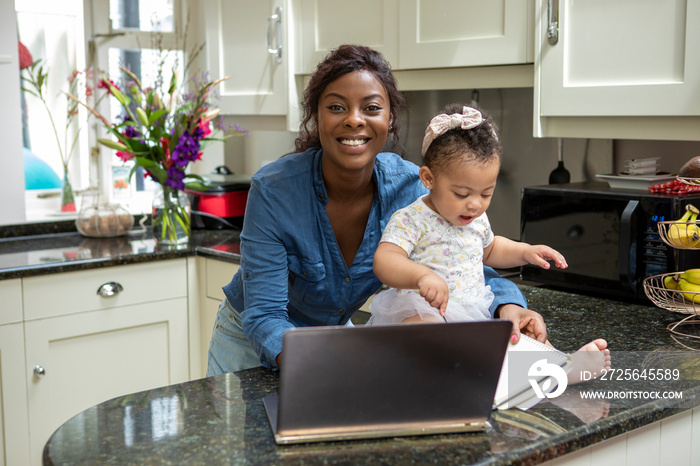 在家用笔记本电脑工作并照顾婴儿女儿（12-17个月）的女性