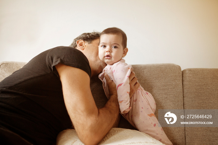 Portrait of father kissing daughter (2-5 months)