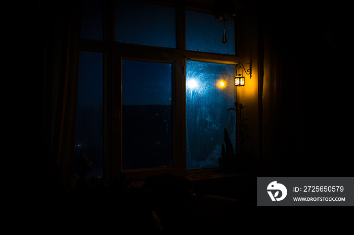 Night scene of stars seen through the window from dark room. Night sky inside dark room viewing from