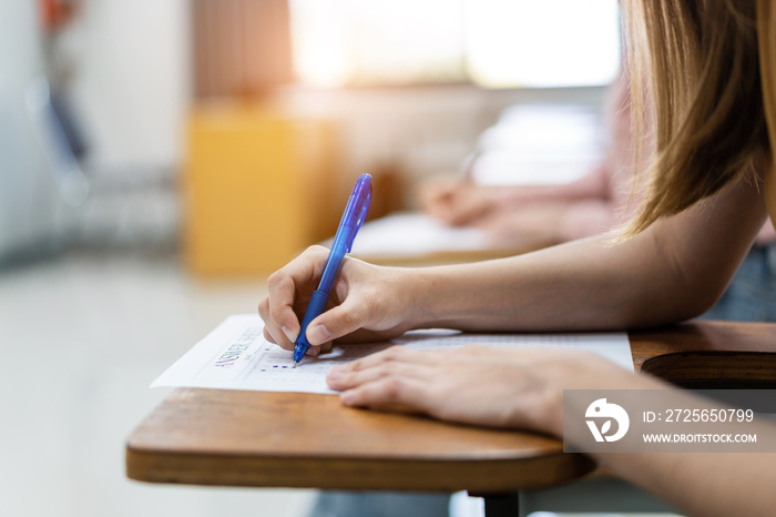 Close up of young female university students concentrate on doing examination in the classroom. Girl