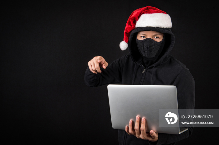 mysterious male santa hacker holding laptop computer