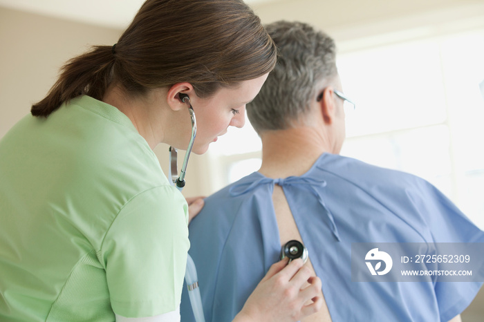 nurse examining senior male patient