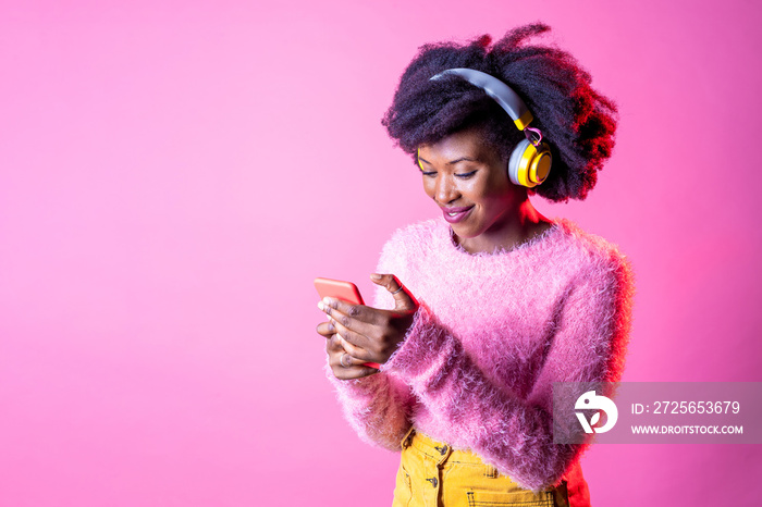 年轻漂亮的黑人女人发短信给智能手机听音乐