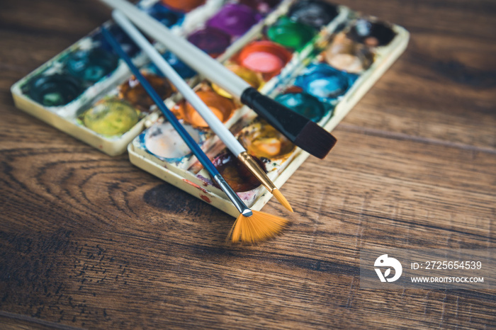 brushes with watercolor on the desk