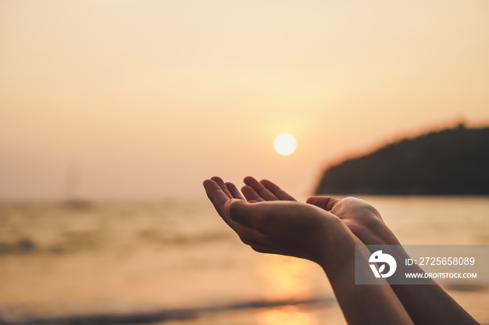 Woman hands place together like praying in front of nature green  background.