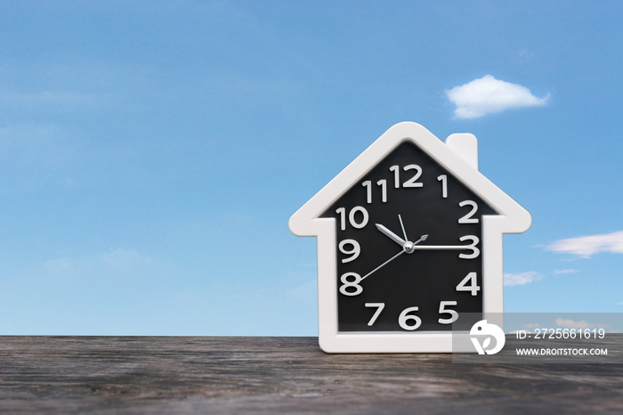 Alarm clock on the wood table and background sky view with copy space for texture ,time concept.