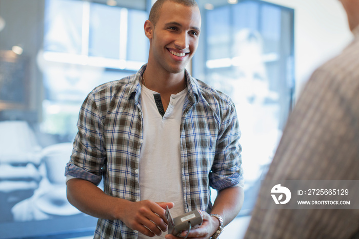 Attractive African American man paying for purchase at store