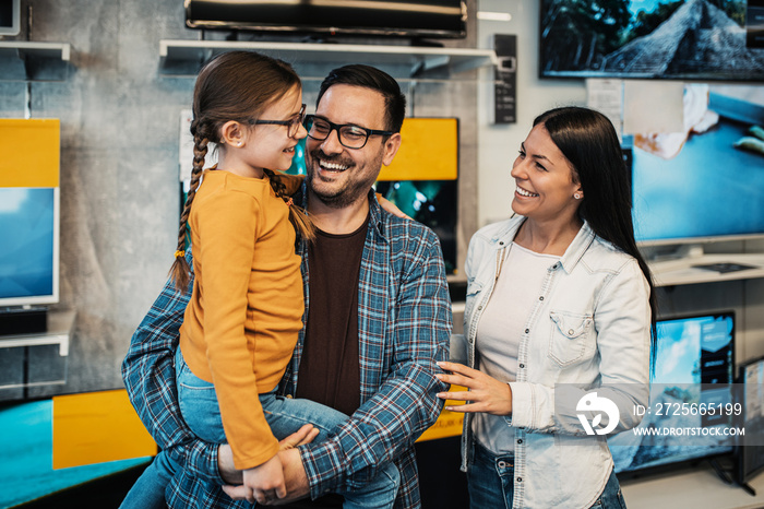 Happy family buying TV in store.