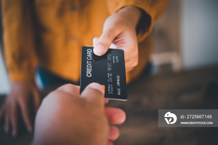 使用信用卡付款的特写，将信用卡发送给信用卡处的工作人员