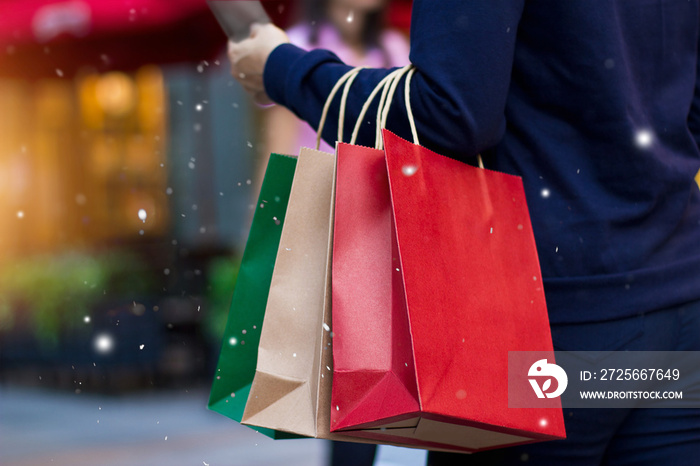 圣诞购物-圣诞节装饰和灯光上的雪花在手的购物袋