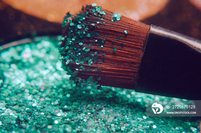 Makeup brush on green shiny shadows. Bright shadows with glitter glitter. Macro frame of shadows. Br