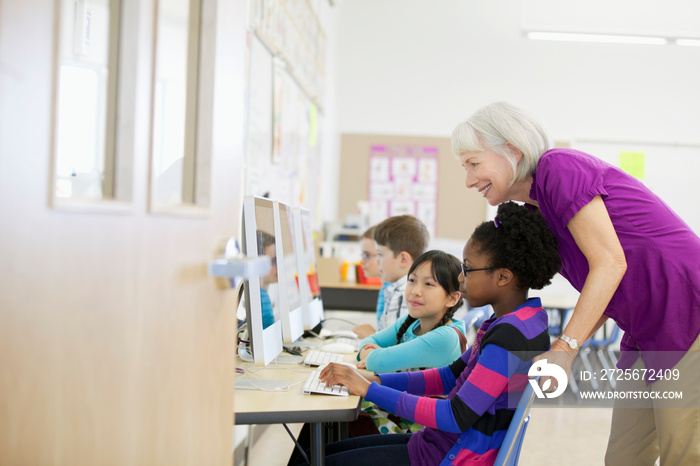 teacher assisting students in computer lab