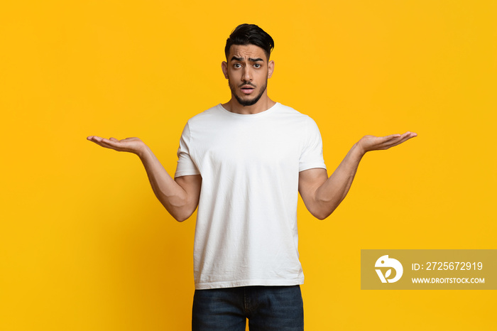 Confused middle eastern man holding something on both hands