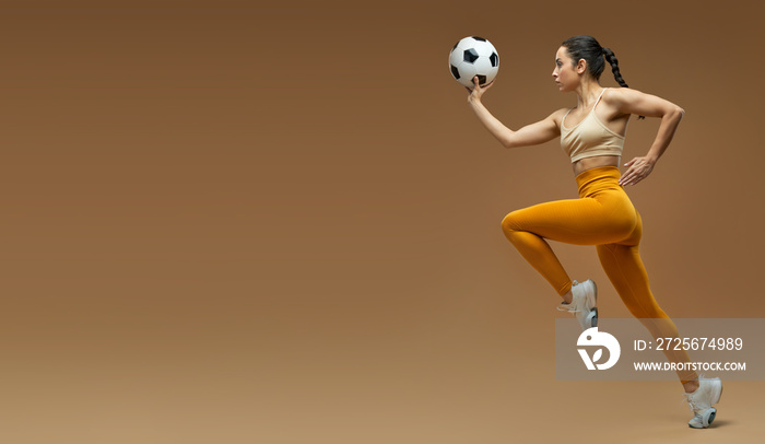 Website header of Athletic young woman with soccer ball running in studio