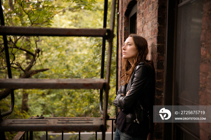 Young woman leaning on wall