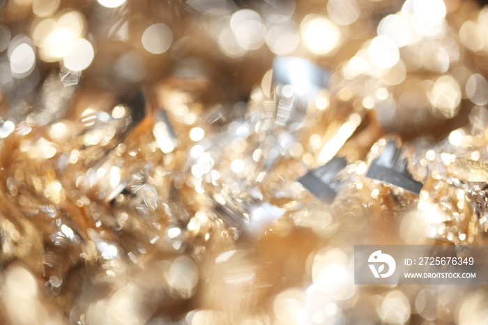 Abstract bokeh of sparkling gold and silver Christmas tinsel background