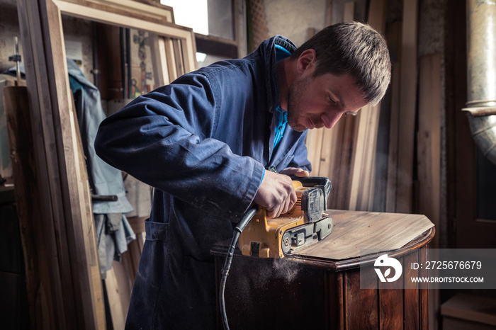 木匠用砂带打磨机修复家具