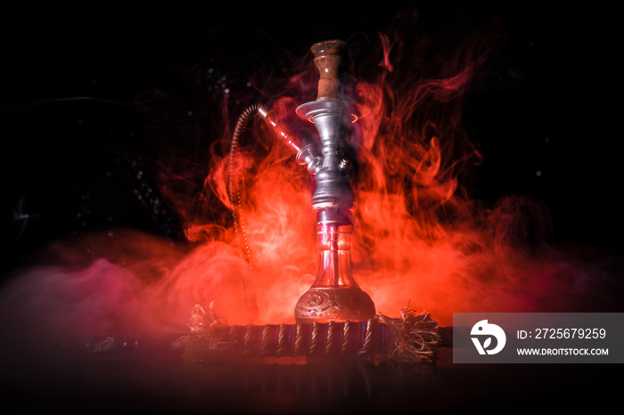 Hookah hot coals on shisha bowl on dark foggy background. Stylish oriental shisha.