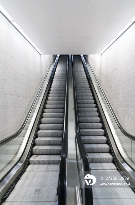 vertical view of a long an empty escalator in a train station