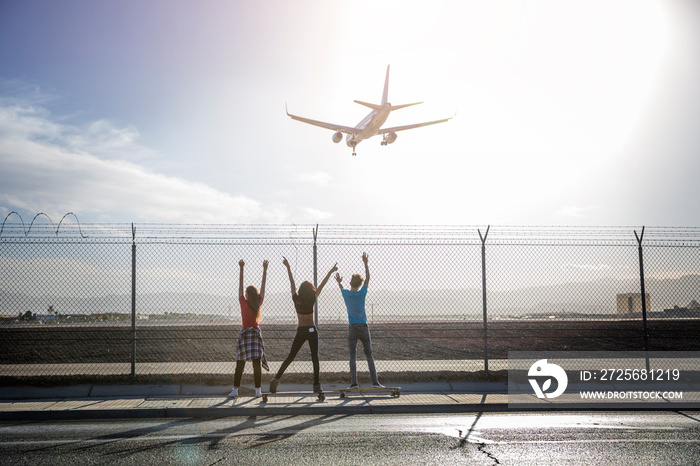 Young people looking at airplane in flight