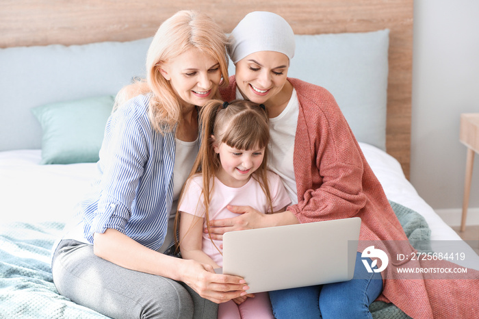 Woman after chemotherapy and her family with laptop at home