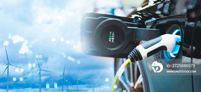 Double exposure of vehicle electric car charge battery with wind turbine and blue sky blur bokeh on 