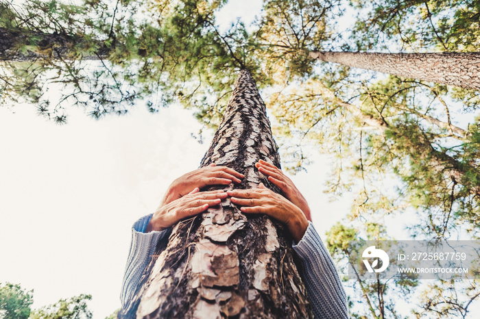 People protecting trees from deforestation concept with couple of senior caucasian hands hugging wit