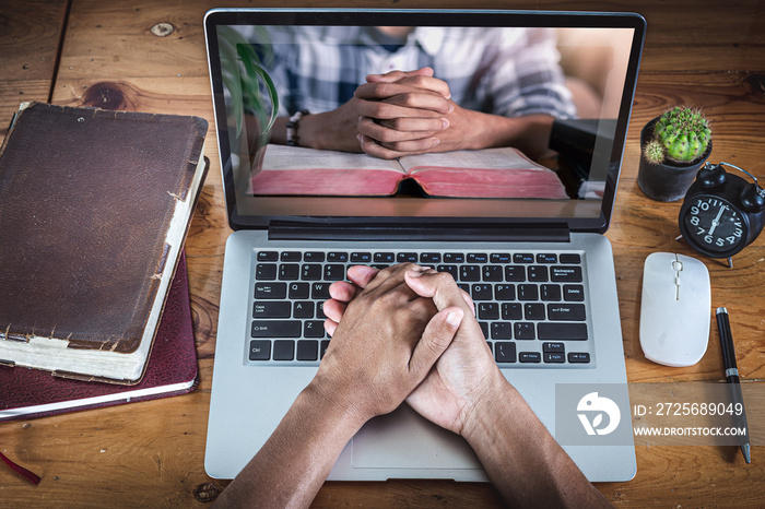 Hands praying with computer laptop, Online live church for sunday service, Home church during quaran