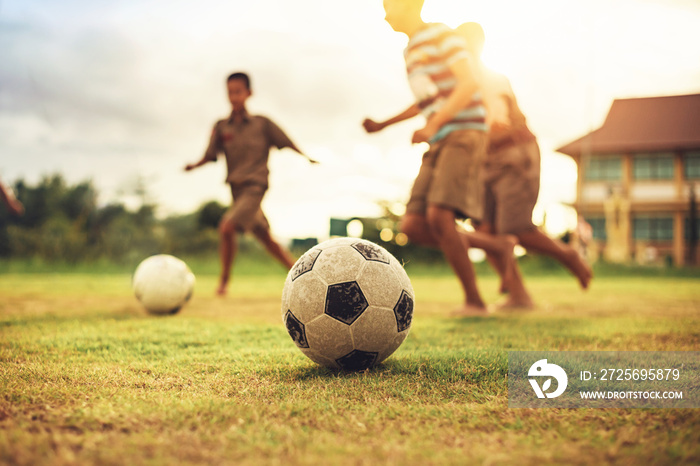 Silhouette action sport outdoors of a group of kids having fun playing soccer football for exercise 