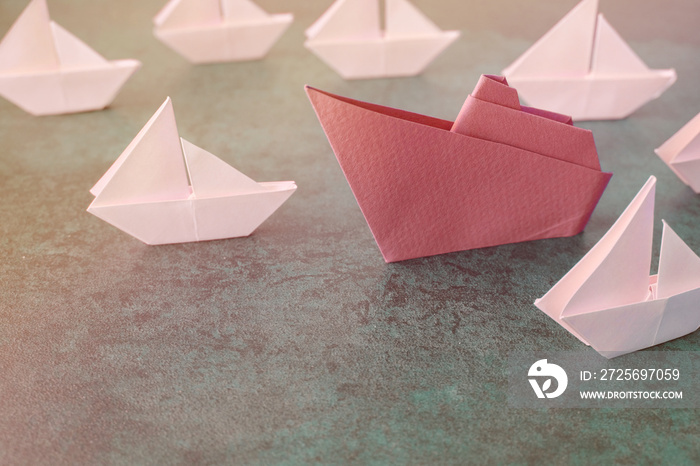 Origami paper ship with small sailboats, female woman leadership business , disruptive innovation co