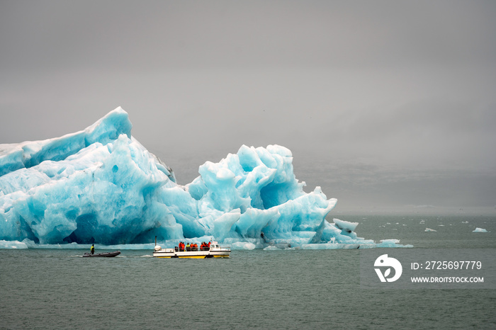 jokulsarlon冰川泻湖的大冰山中有游客乘坐的水陆两用车。融化，世界，旅行